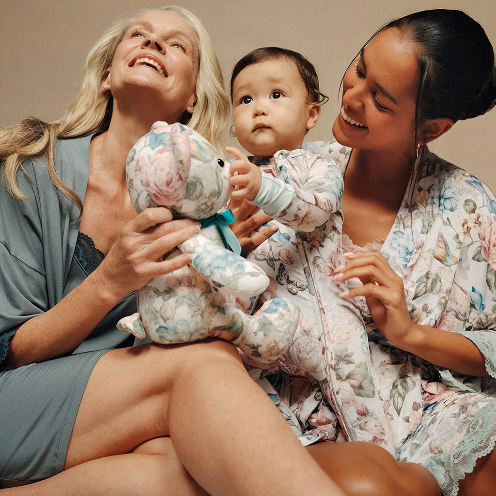 mother and grandmother with infant and stuffed bear